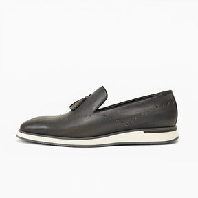 Loafer masculino com tassel e tachas metálicas, couro legítimo texturizado, solado branco e design sofisticado e moderno.