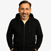 Homem vestindo blusa moletom masculina preta com capuz e zíper, estilo casual urbano para dias frios, com mãos nos bolsos e camiseta branca por baixo.