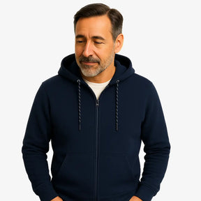 Homem vestindo blusa moletom masculina azul marinho com capuz e zíper, estilo casual urbano para dias frios, com mãos nos bolsos e camiseta branca por baixo.