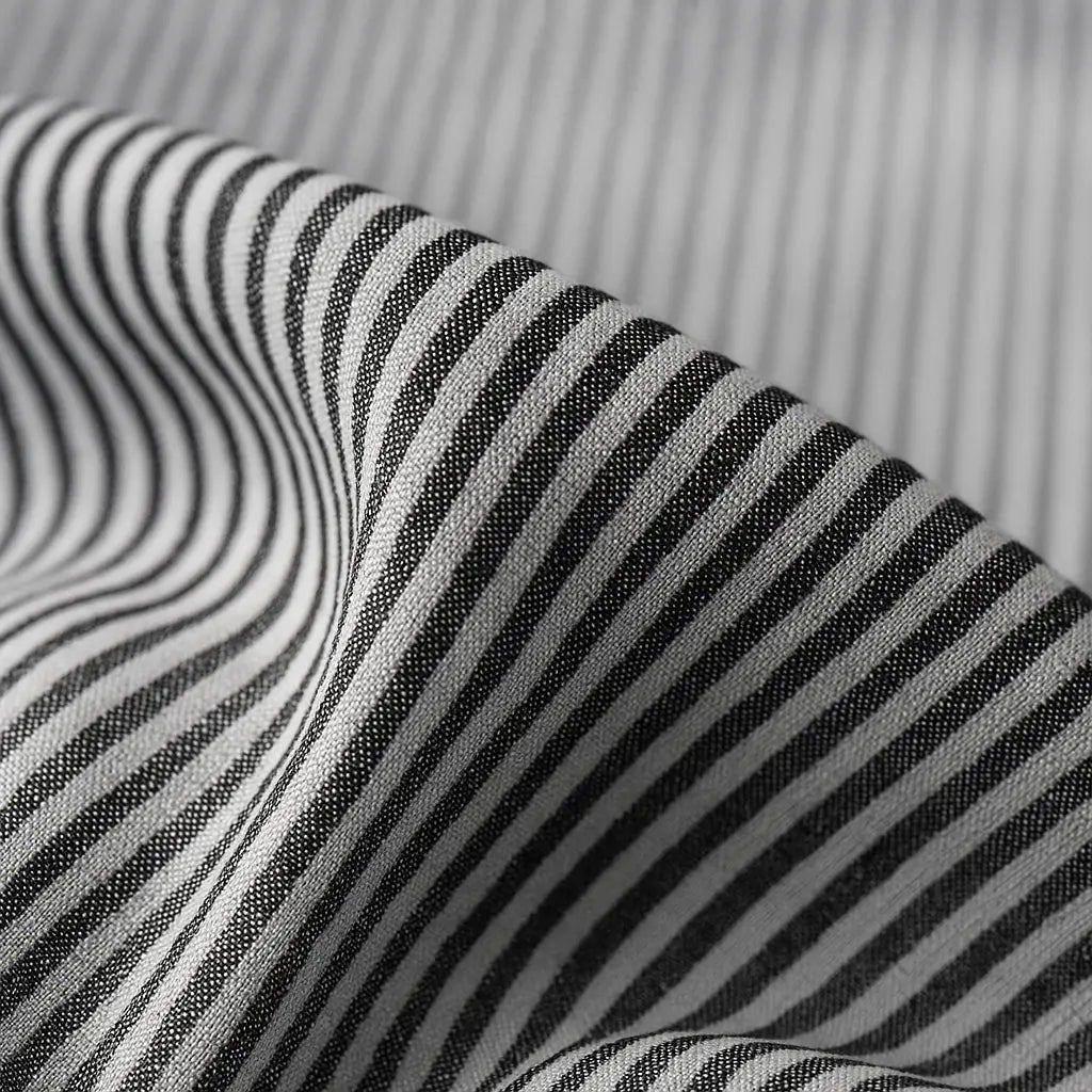 camisa social masculina listrada preta e branca em algodão, manga longa, modelagem slim fit, dobrada sobre fundo claro