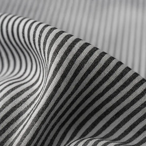 camisa social masculina listrada preta e branca em algodão, manga longa, modelagem slim fit, dobrada sobre fundo claro