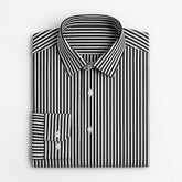 camisa social masculina listrada preta e branca em algodão, manga longa, modelagem slim fit, dobrada sobre fundo claro