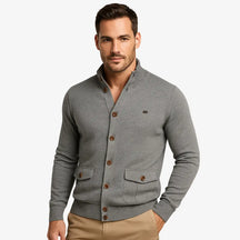 Modelo masculino usando cardigan cinza de botão com bolsos frontais, estilo social casual, calça chino bege. Ideal para outono/inverno