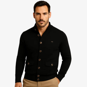 Modelo masculino usando cardigan preto de botão com bolsos frontais, estilo social casual, calça chino bege. Ideal para outono/inverno