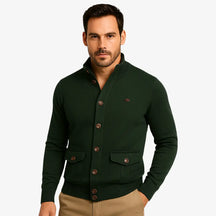 Modelo masculino usando cardigan verde de botão com bolsos frontais, estilo social casual, calça chino bege. Ideal para outono/inverno