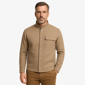 Homem vestindo jaqueta masculina bege com gola alta, bolso superior e fechamento por botões