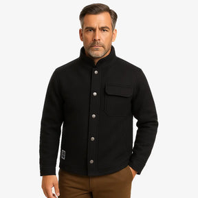 Homem vestindo jaqueta masculina preta com gola alta, bolso superior e fechamento por botões