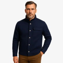 Homem vestindo jaqueta masculina azul marinho com gola alta, bolso superior e fechamento por botões