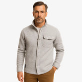 Homem vestindo jaqueta masculina cinza com gola alta, bolso superior e fechamento por botões