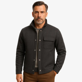 Homem vestindo jaqueta masculina cinza  com gola alta, bolso superior e fechamento por botões
