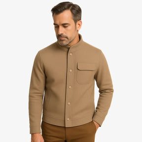 Homem vestindo jaqueta masculina bege com gola alta, bolso superior e fechamento por botões