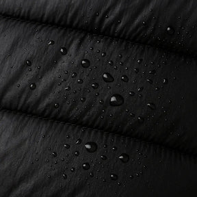 Homem vestindo jaqueta puffer masculina preta com capuz, impermeável e com zíper frontal, ideal para o inverno.
