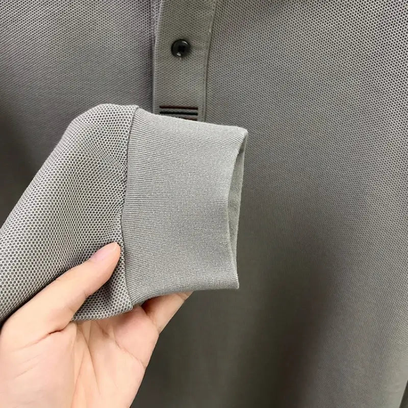 camisa polo masculina manga longa com tecido piquet respirável exibida em cabide mostrando textura tecnológica do tecido