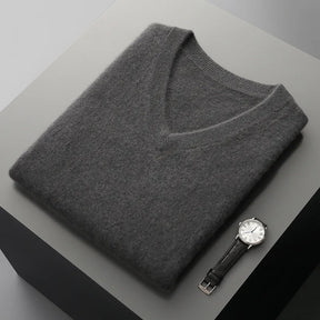 Colete masculino em lã  com gola V dobrado sobre superfície minimalista com visual elegante