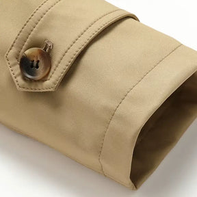 Trench coat masculino com cinto, abotoamento duplo, gola clássica e estilo britânico elegante.