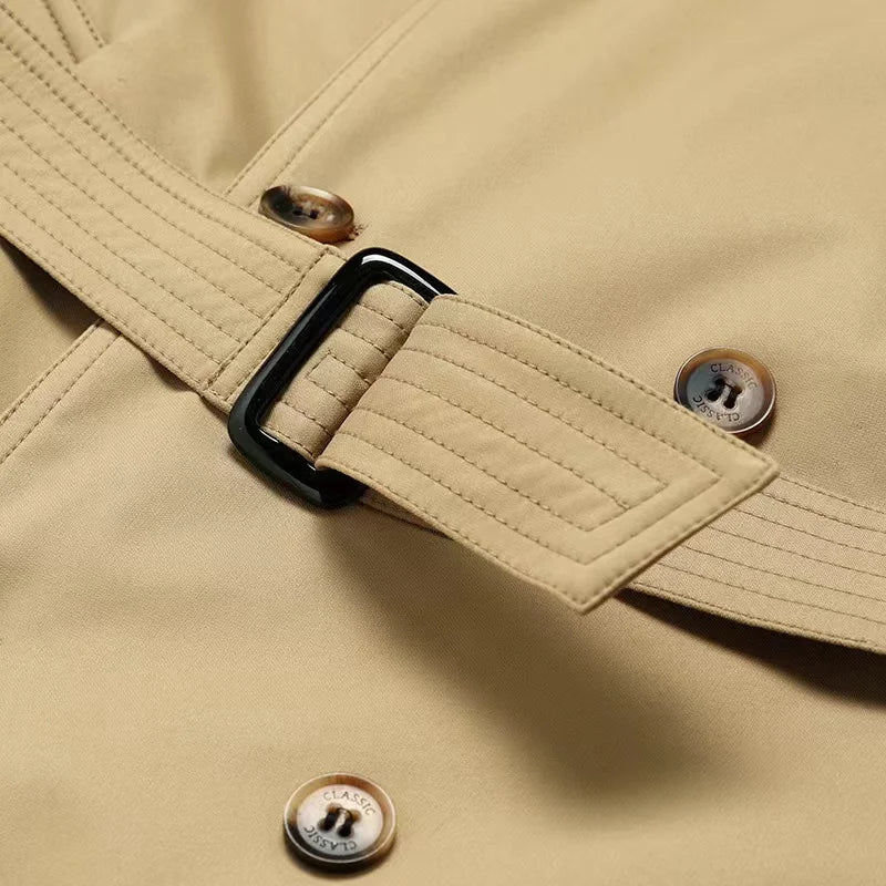 Trench coat masculino com cinto, abotoamento duplo, gola clássica e estilo britânico elegante.