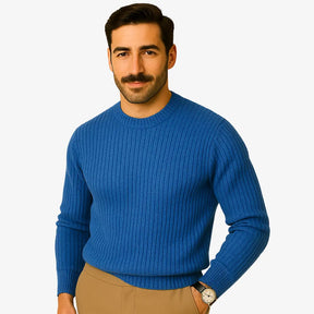 Homem elegante usando suéter de lã azul com textura canelada, gola careca e calça chino bege. Visual sofisticado para o inverno