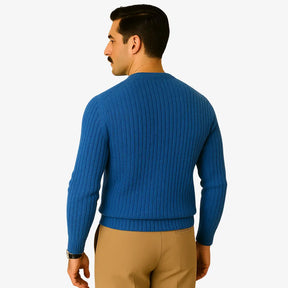 Homem elegante usando suéter de lã azul com textura canelada, gola careca e calça chino bege. Visual sofisticado para o inverno